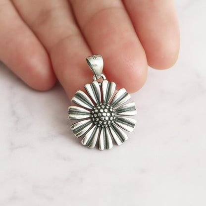 Daisy pendant charm with textured bead center and ridged petal edges, silver-tone