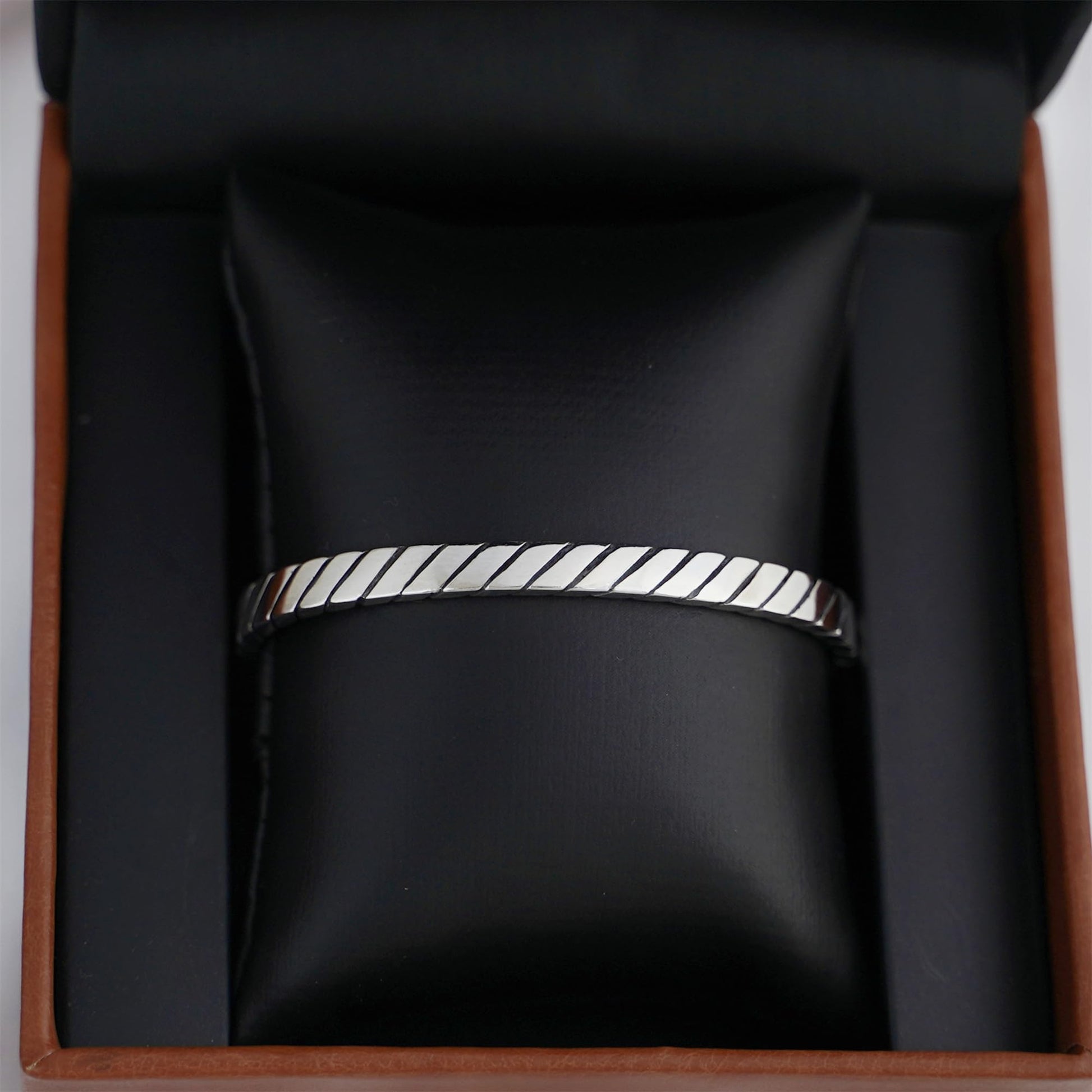 Oxidised rope cuff bangle on display, continuous ridged rope pattern