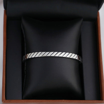 Oxidised rope cuff bangle on display, continuous ridged rope pattern