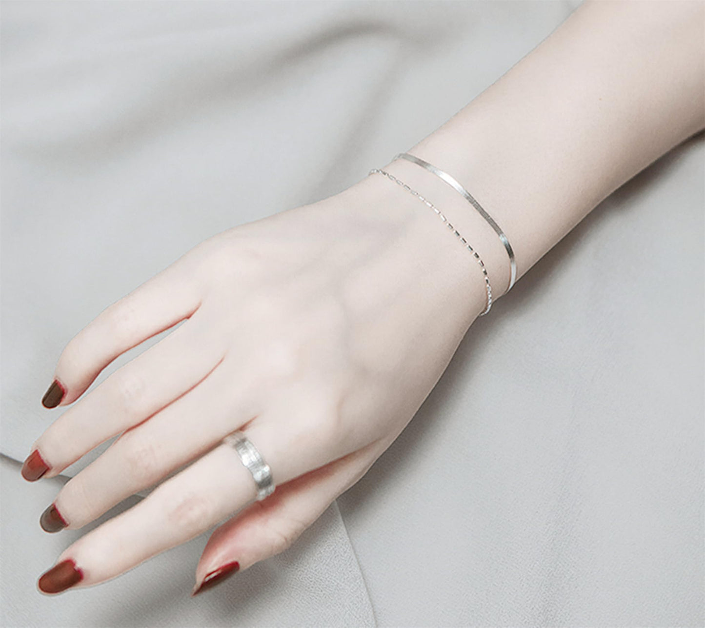 Layered snake bead bracelet worn on wrist with delicate silver-toned chain
