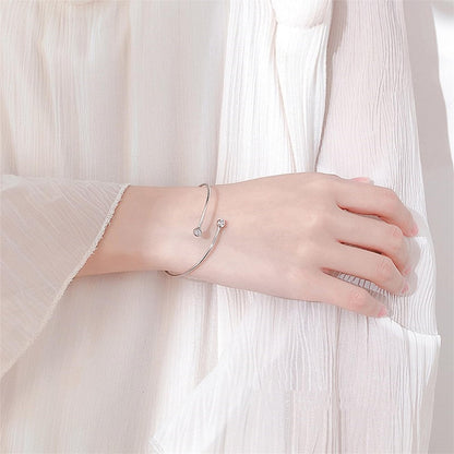 CZ torque bangle worn on wrist, silver tone with two round clear stones
