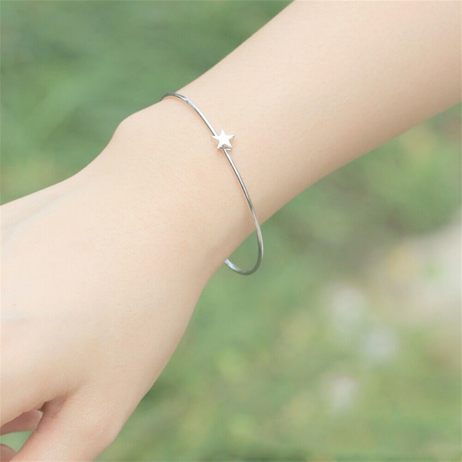Star charm detail on silver-tone torque bangle bracelet