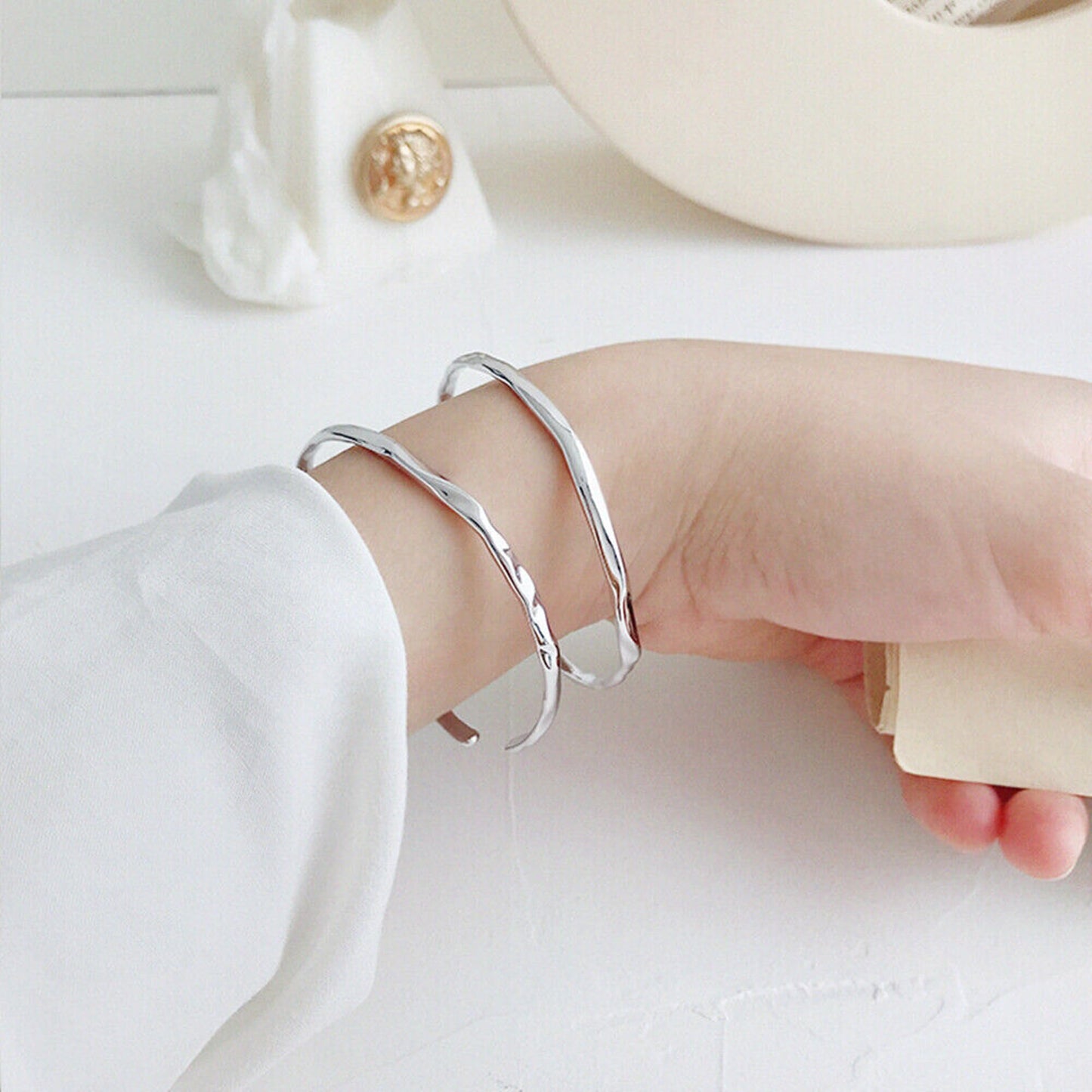 Hammered silver cuff bracelet on wrist with smooth open ends