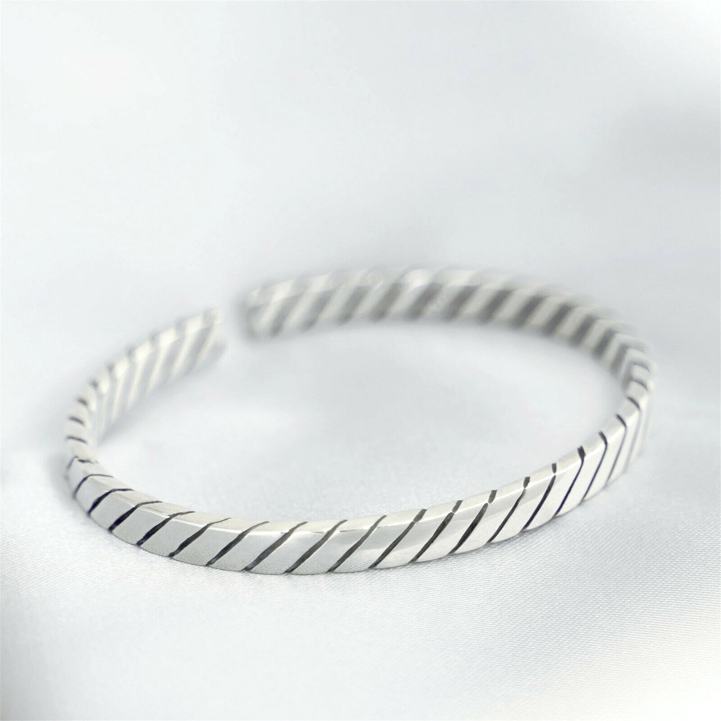 Oxidised rope cuff bangle in silver-tone with dark oxidised lines between ridges