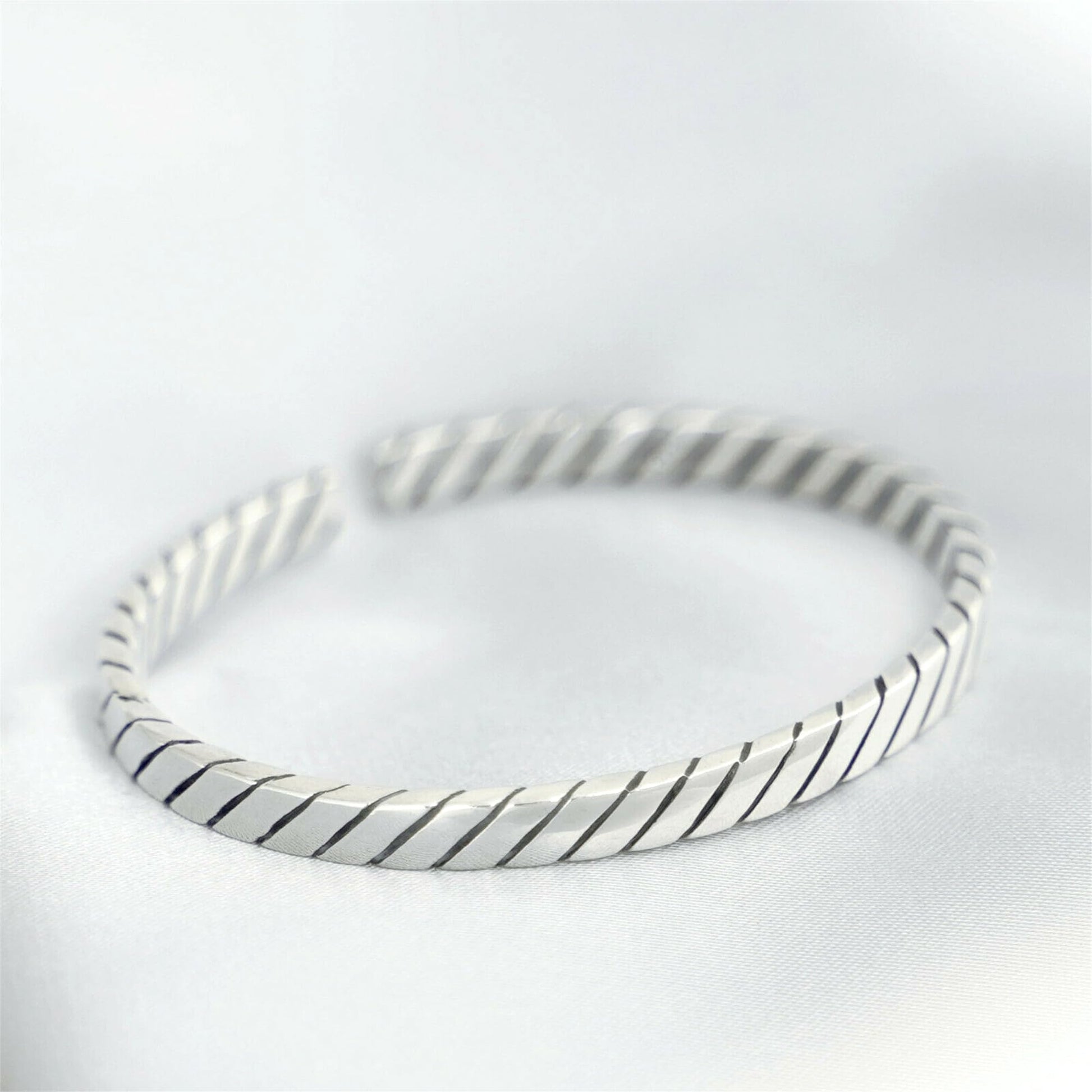 Oxidised rope cuff bangle in silver-tone with dark oxidised lines between ridges