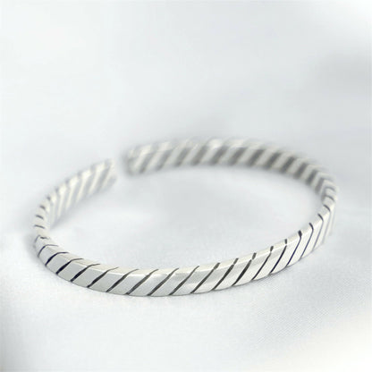 Oxidised rope cuff bangle in silver-tone with dark oxidised lines between ridges