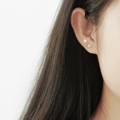 Mini geometric stud earrings on ear: triangle design with shiny silver-tone beads