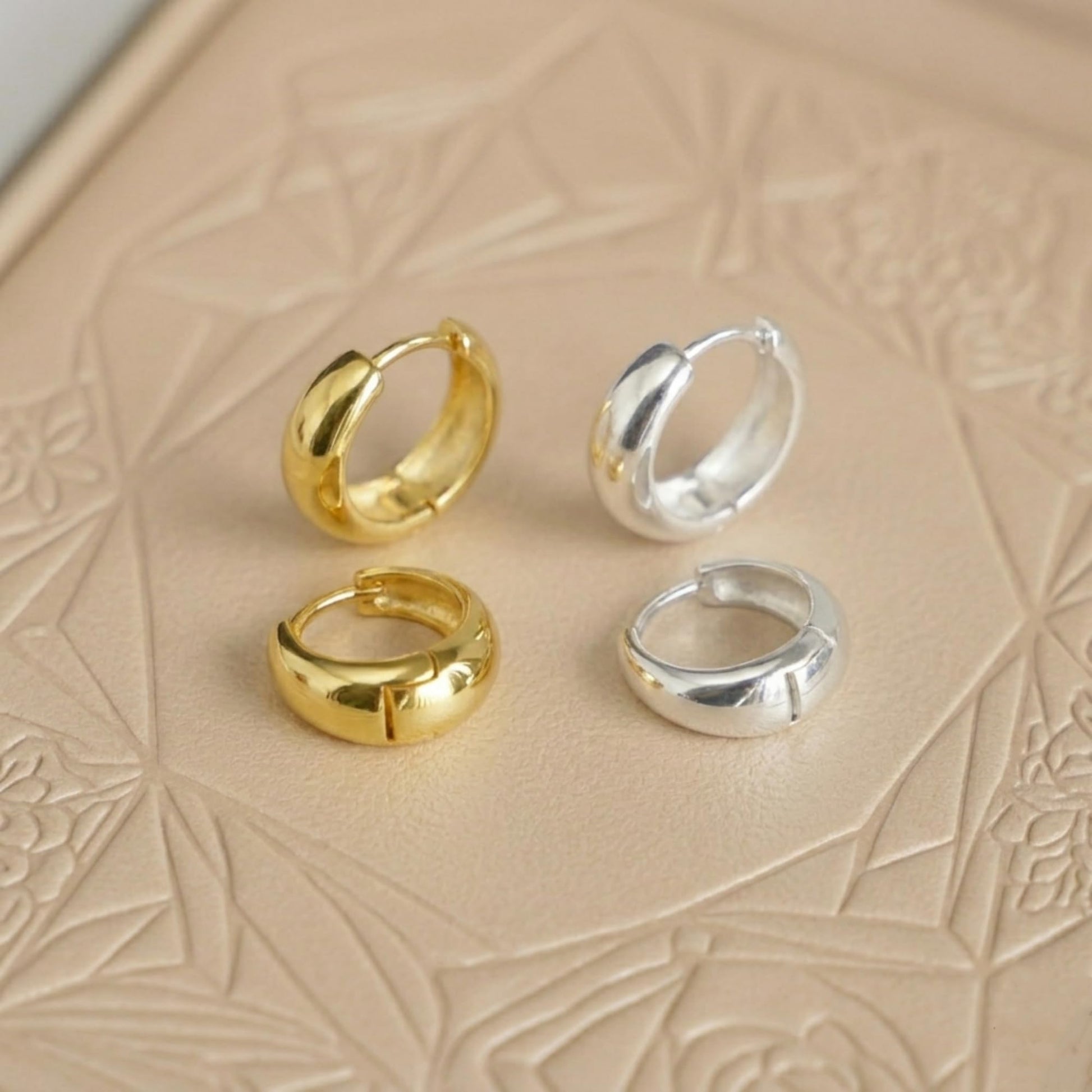 Teardrop hoop huggie earrings: gold and silver pair, front-facing profiles