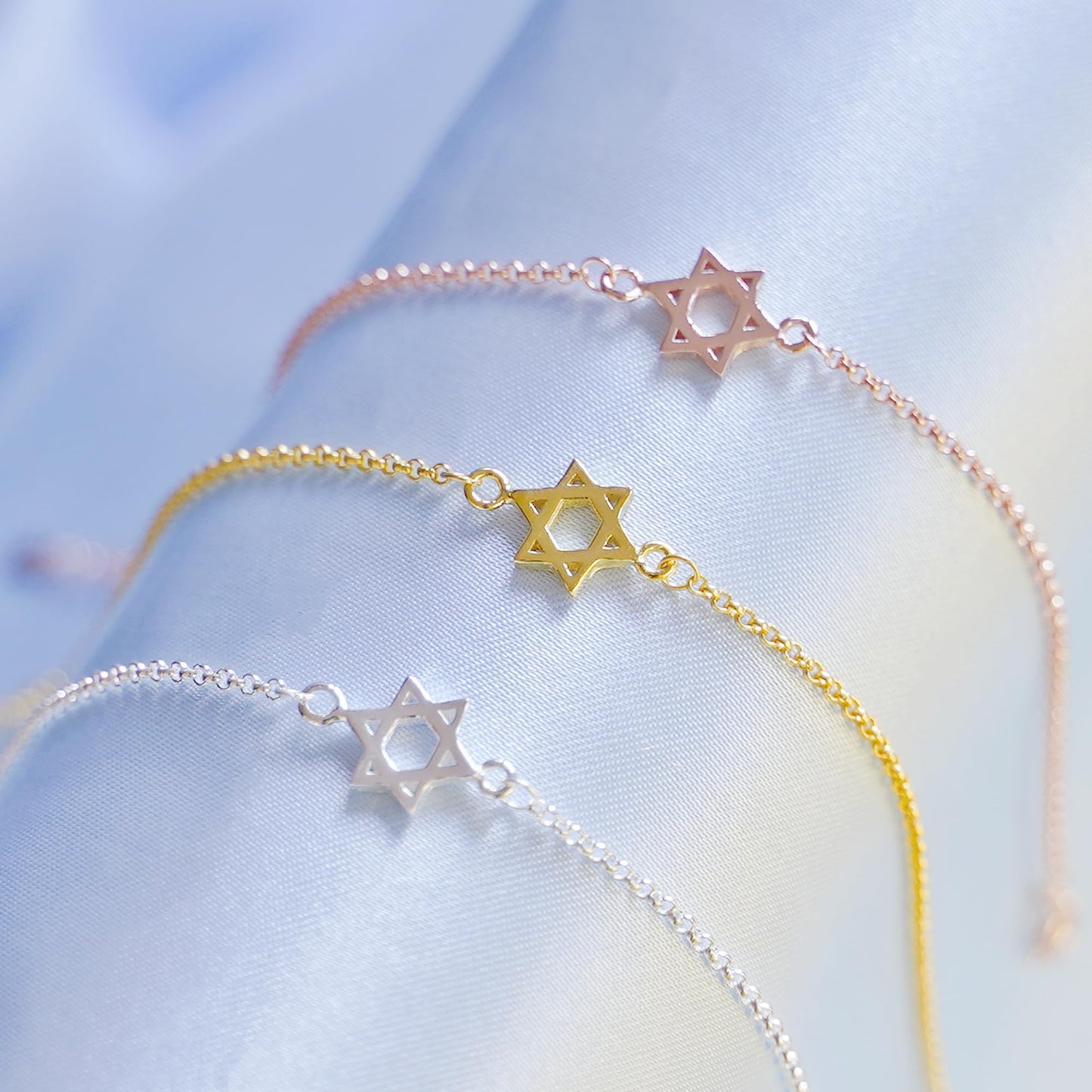 Rose gold Star of David bracelet with star charm near clasp end.