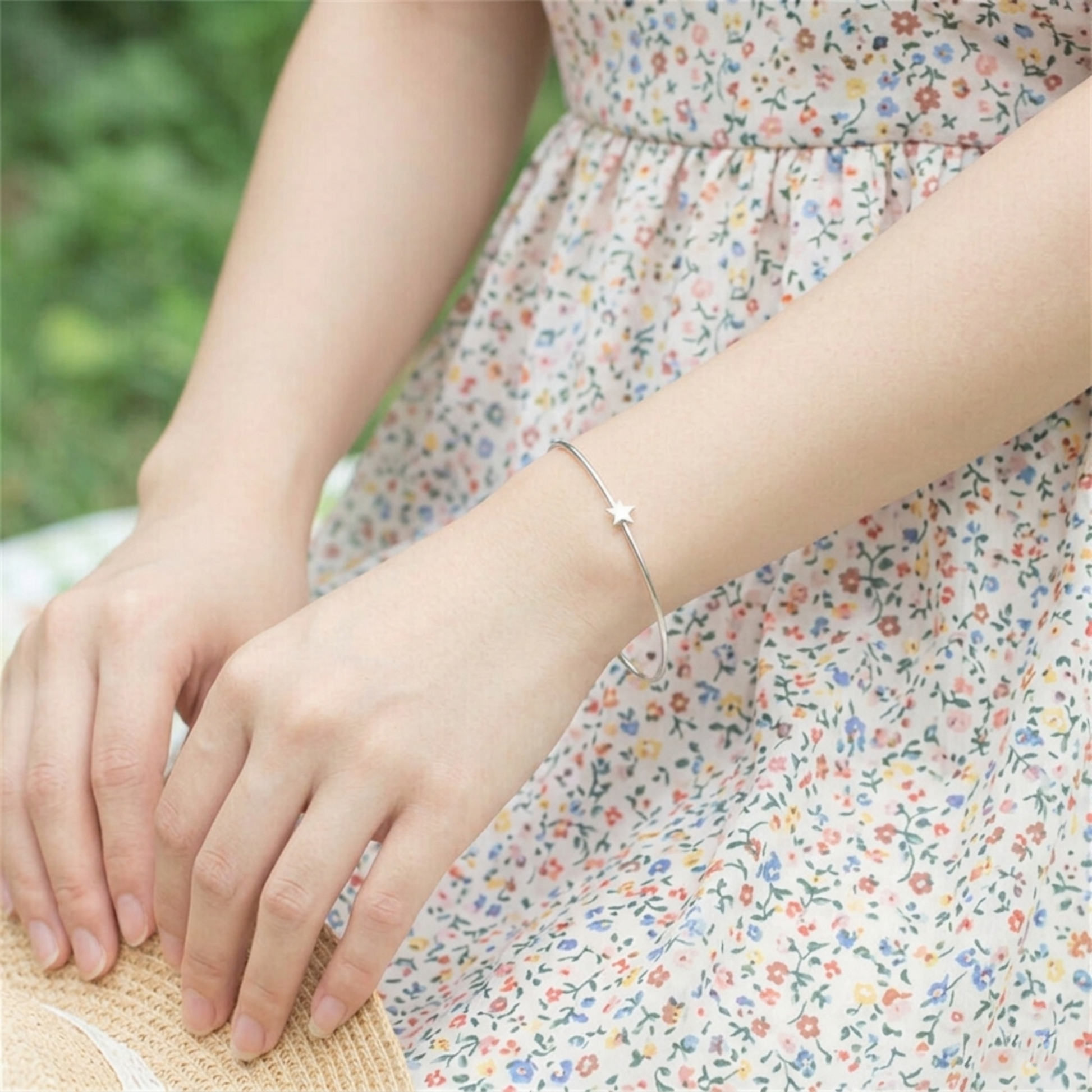 Silver-tone star bead torque bangle on wrist, star charm visible