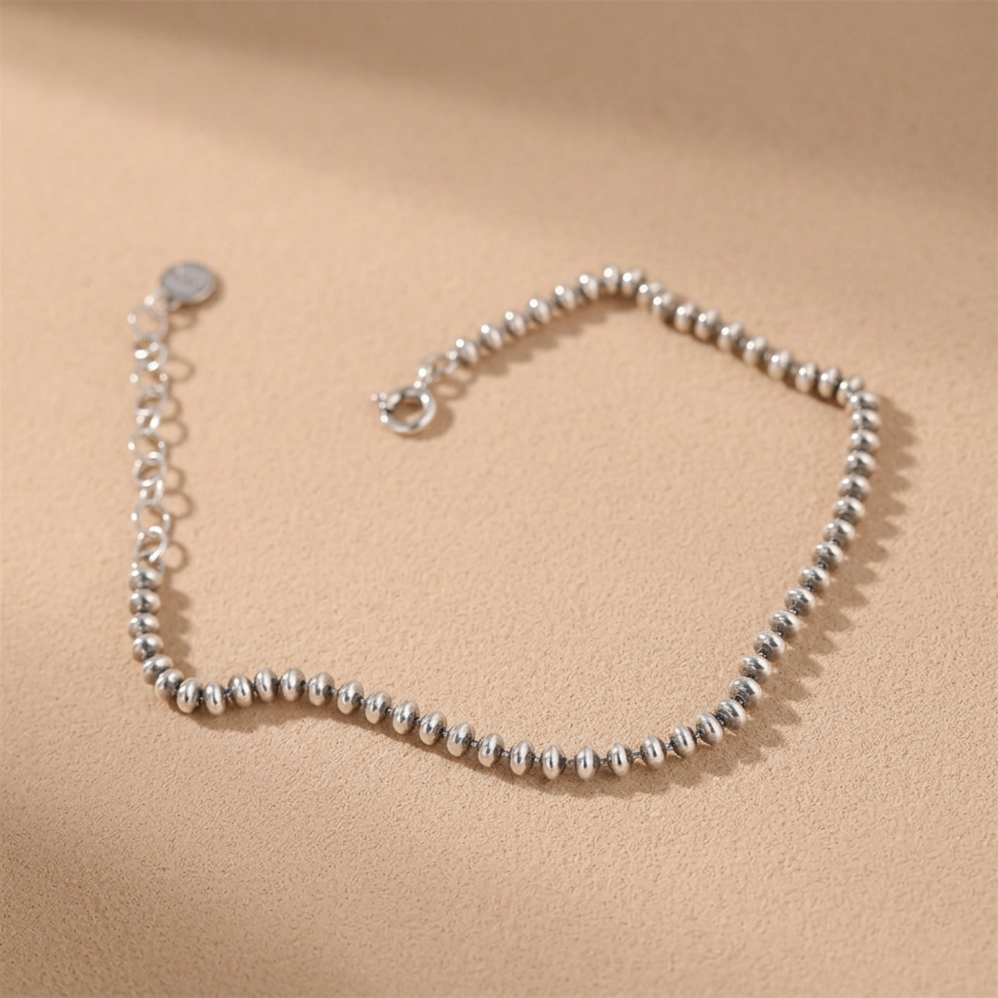 Oxidised flat bead bracelet close-up of silver-toned round beaded chain