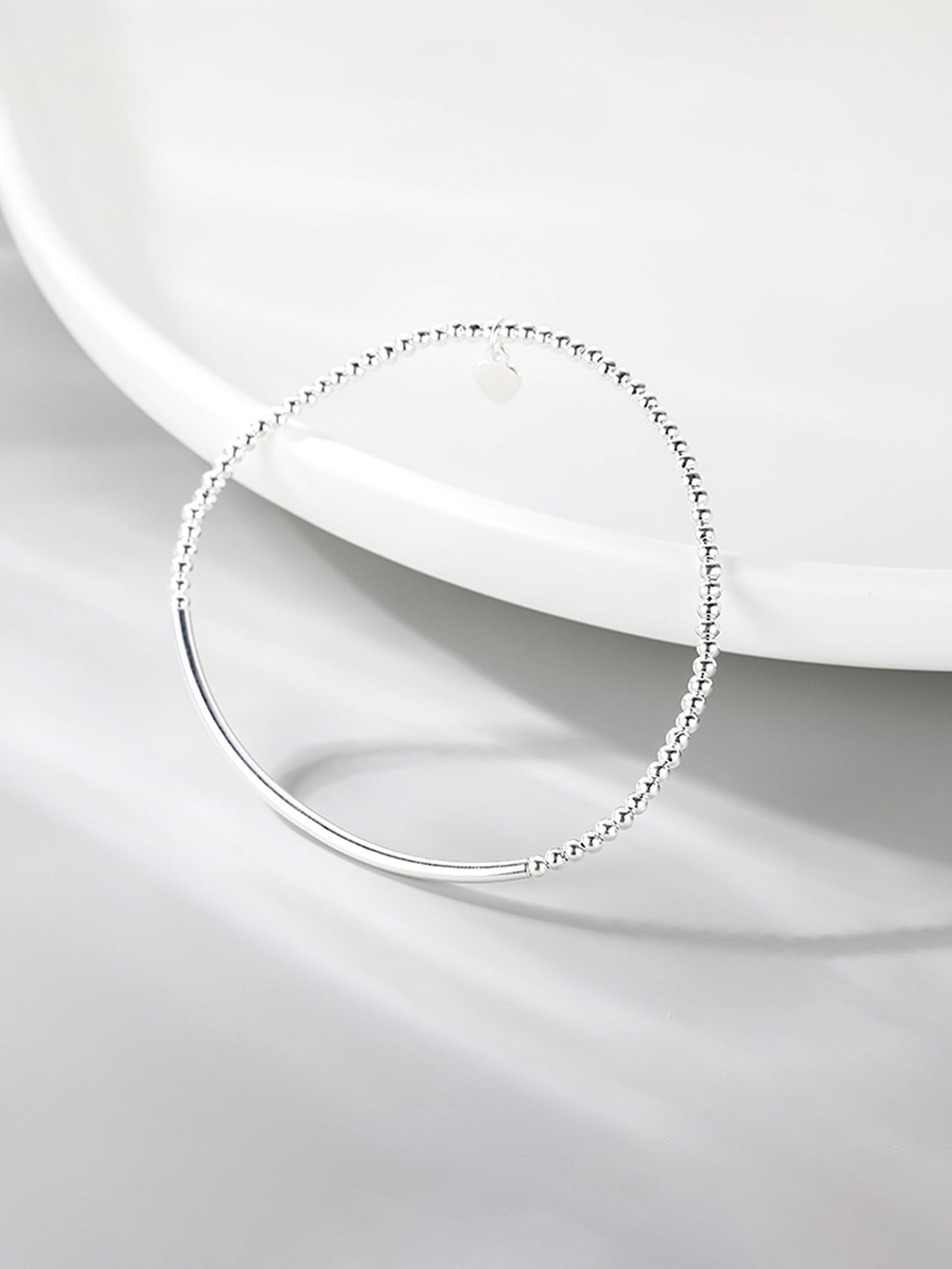 Silver heart charm stretch bracelet with beaded links and smooth curved bar
