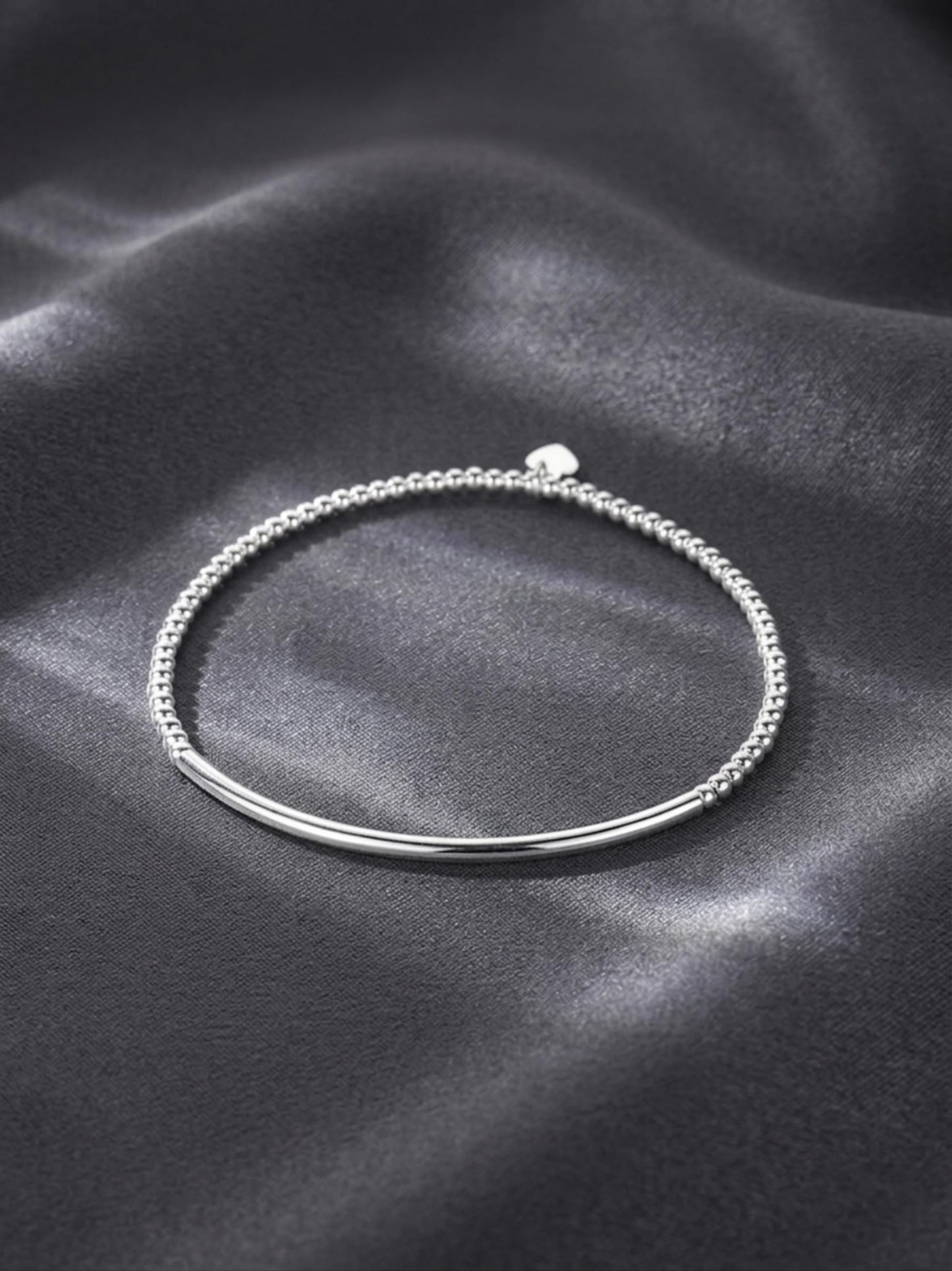 Silver beaded stretch bracelet with small heart charm and curved metal bar