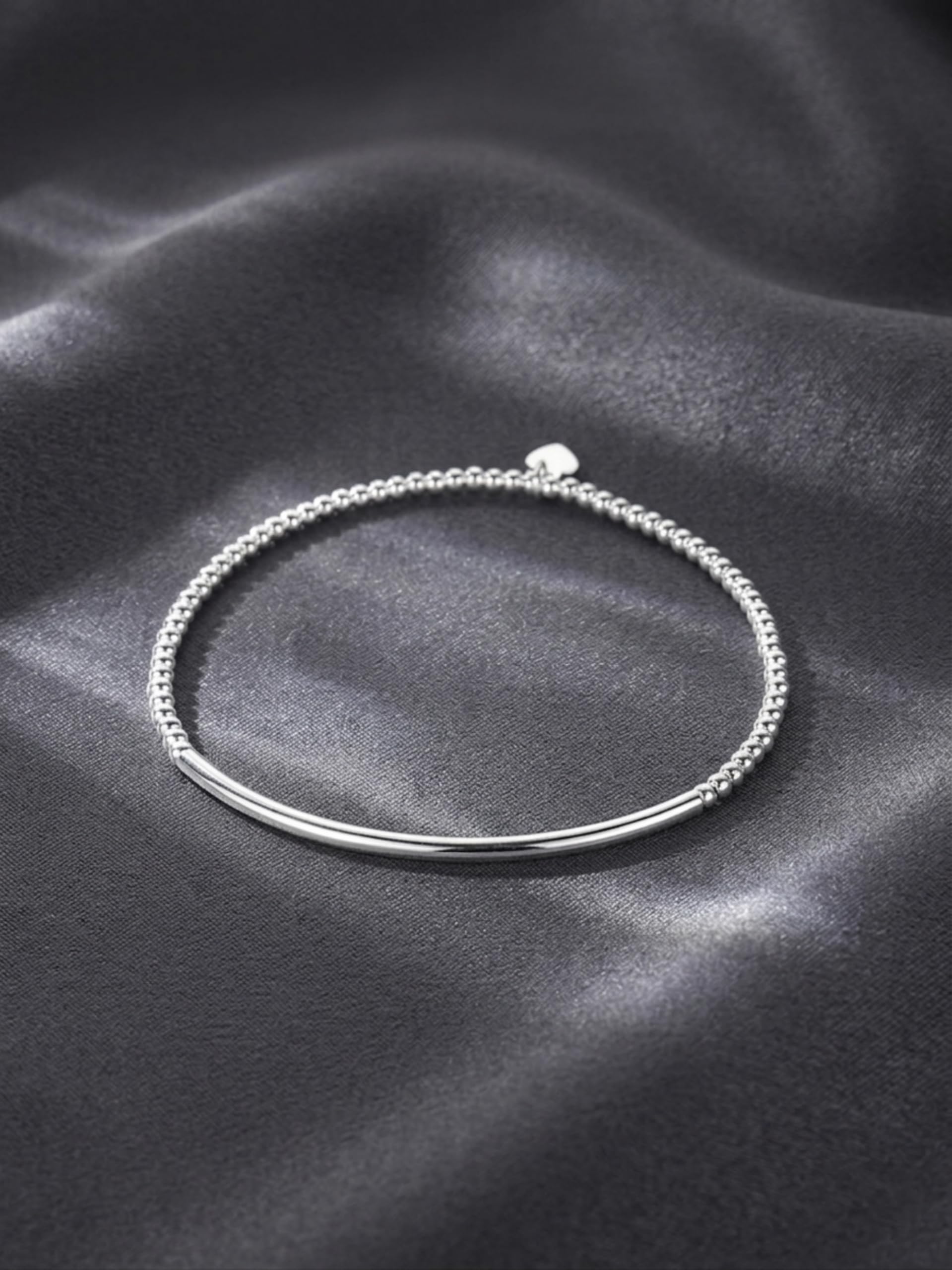 Silver beaded stretch bracelet with small heart charm and curved metal bar