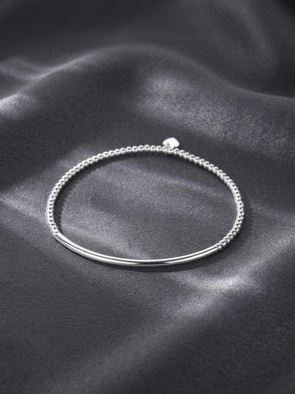 Silver beaded stretch bracelet with small heart charm and curved metal bar