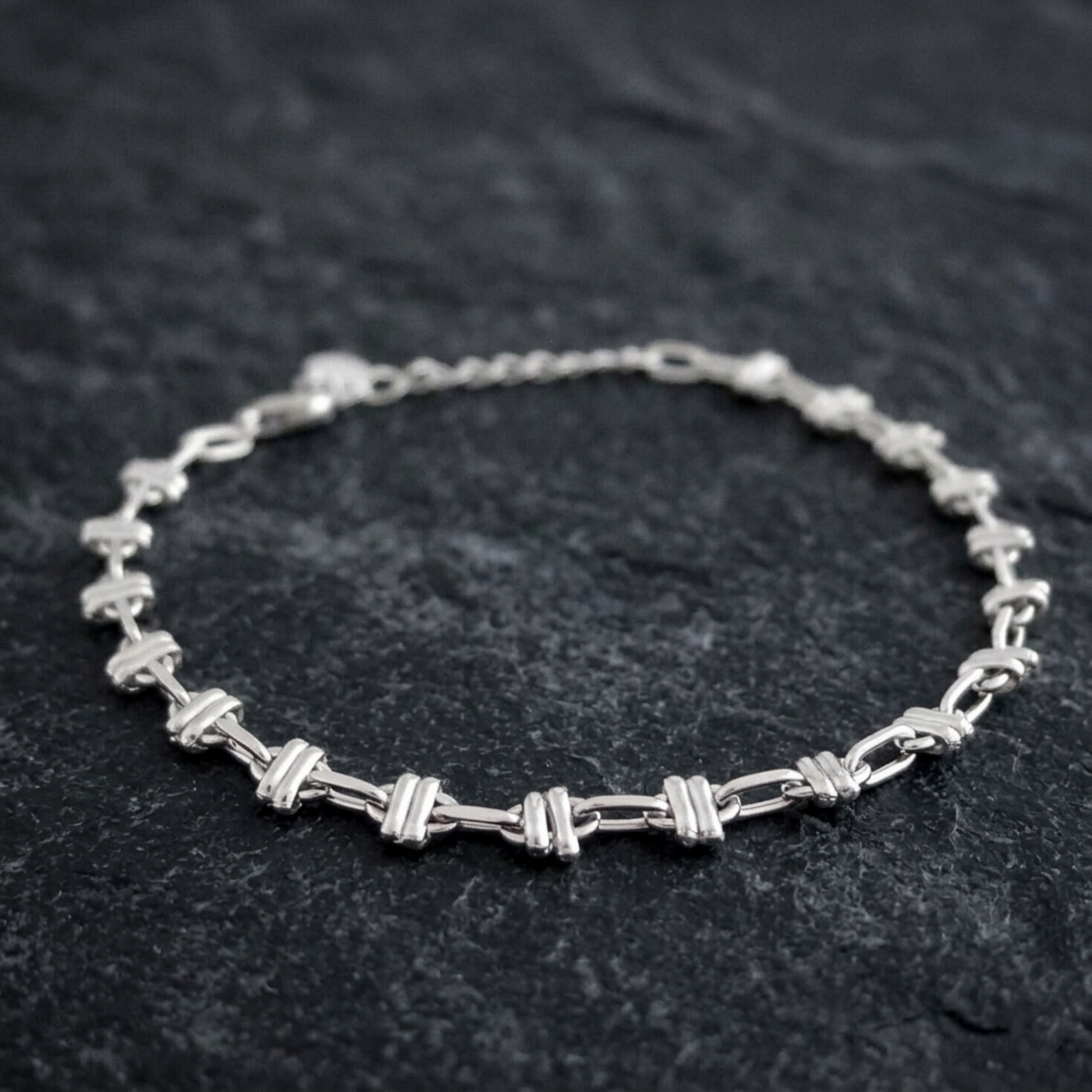 Close-up oval rope curb bracelet: oval link bars on silver-tone curb chain