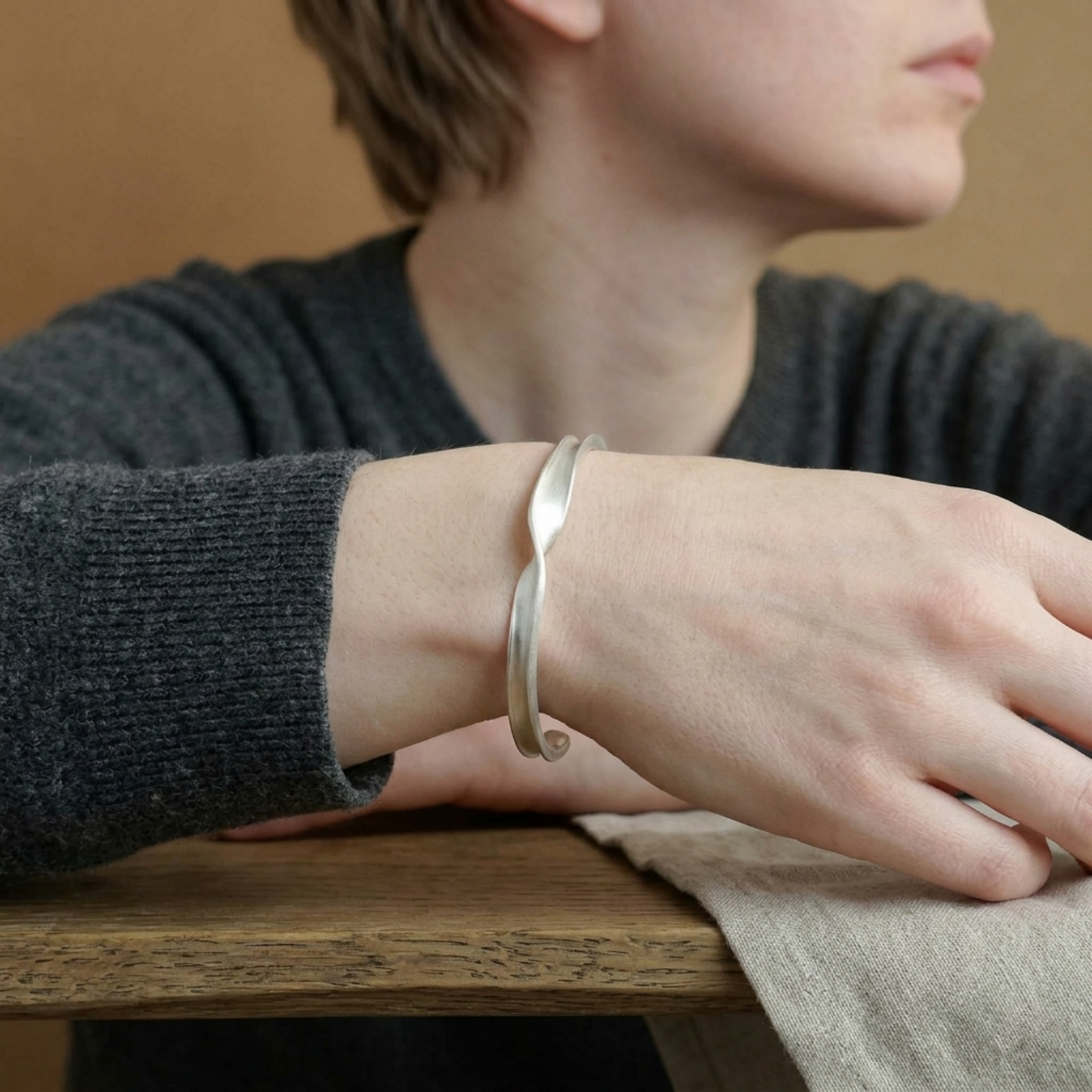 Matte Twist Rope Cuff bracelet on wrist, silver-tone matte twisted rope design
