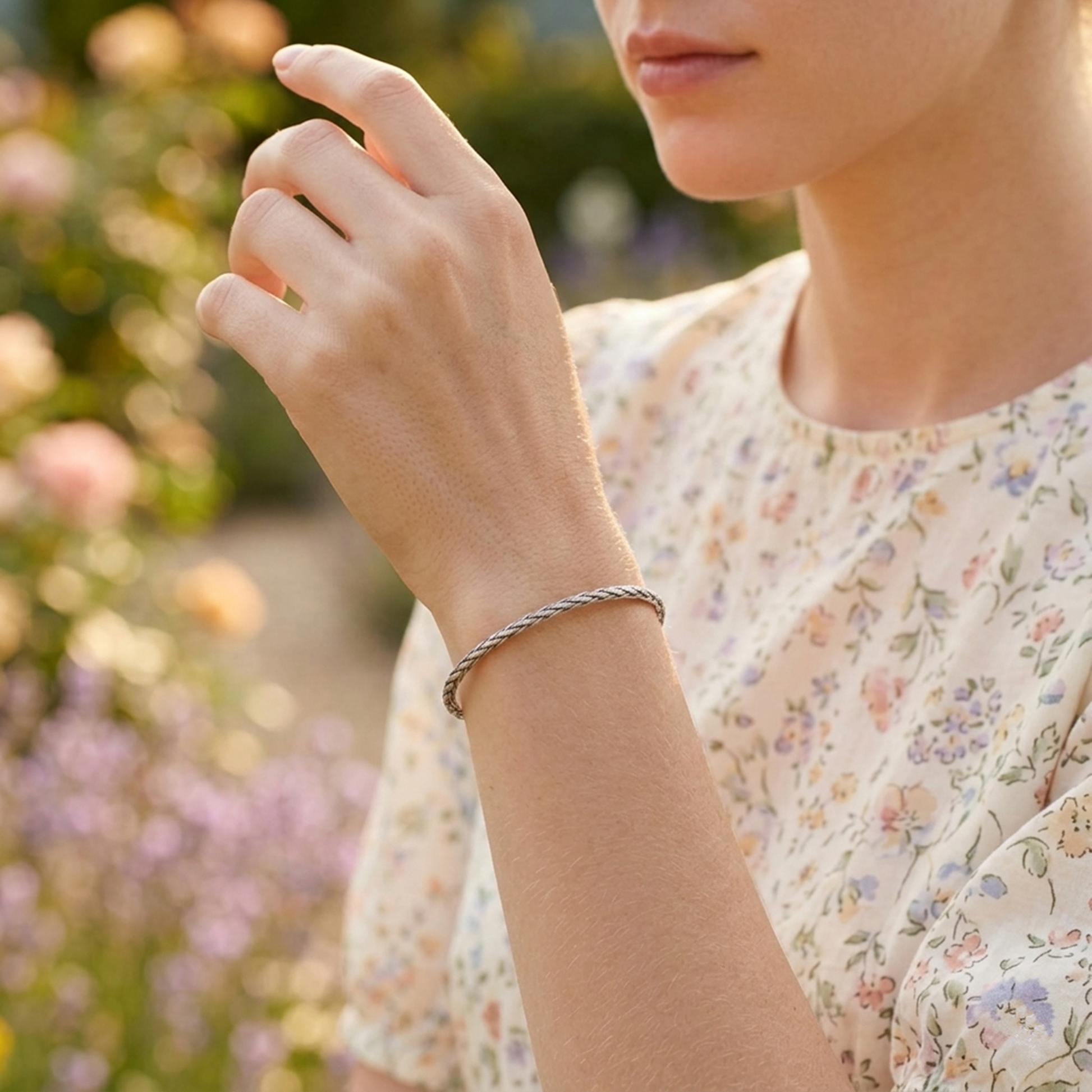 Silver snake-knot cuff bangle with braided chain texture, worn on wrist