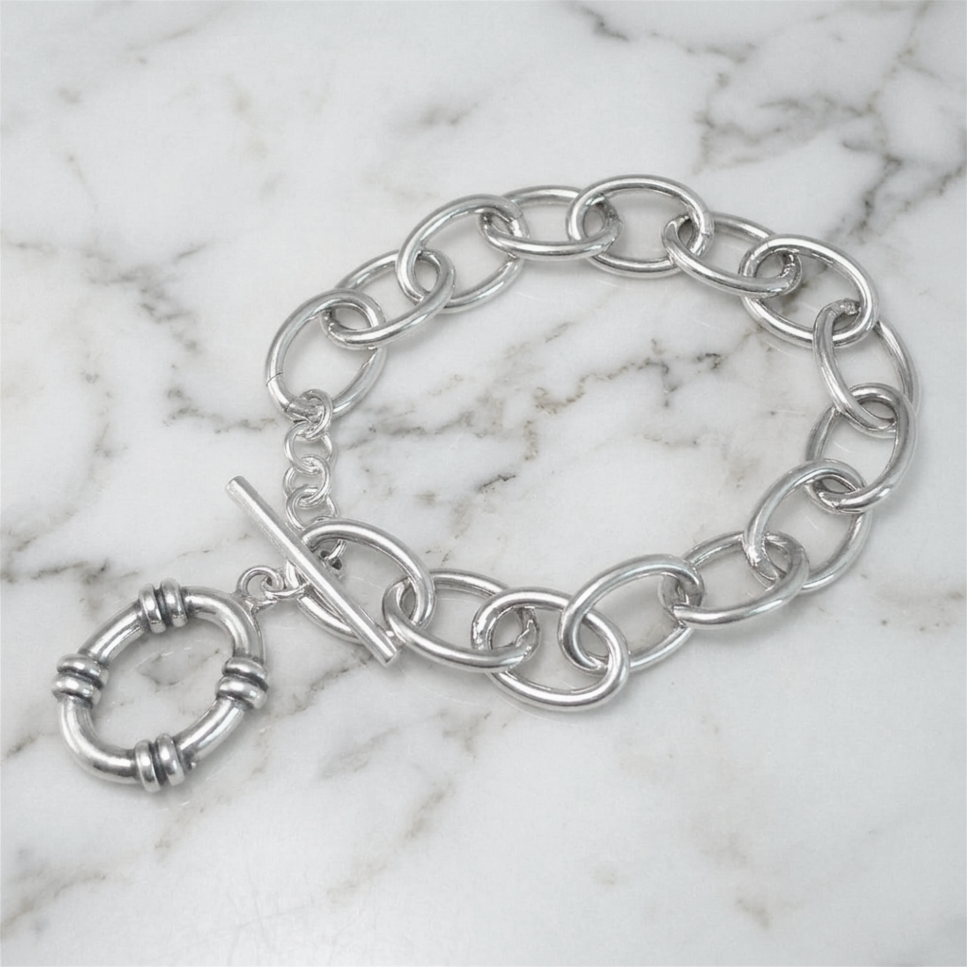 Oxidised linked T-bar bracelet on marble surface with hoop charm and oval links