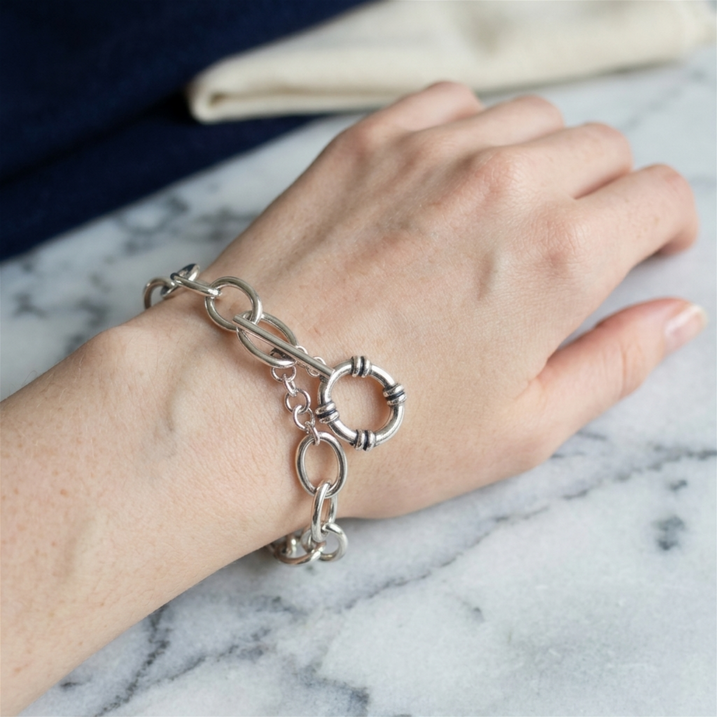Oxidised T-bar bracelet on hand with oval chain links and hoop charm