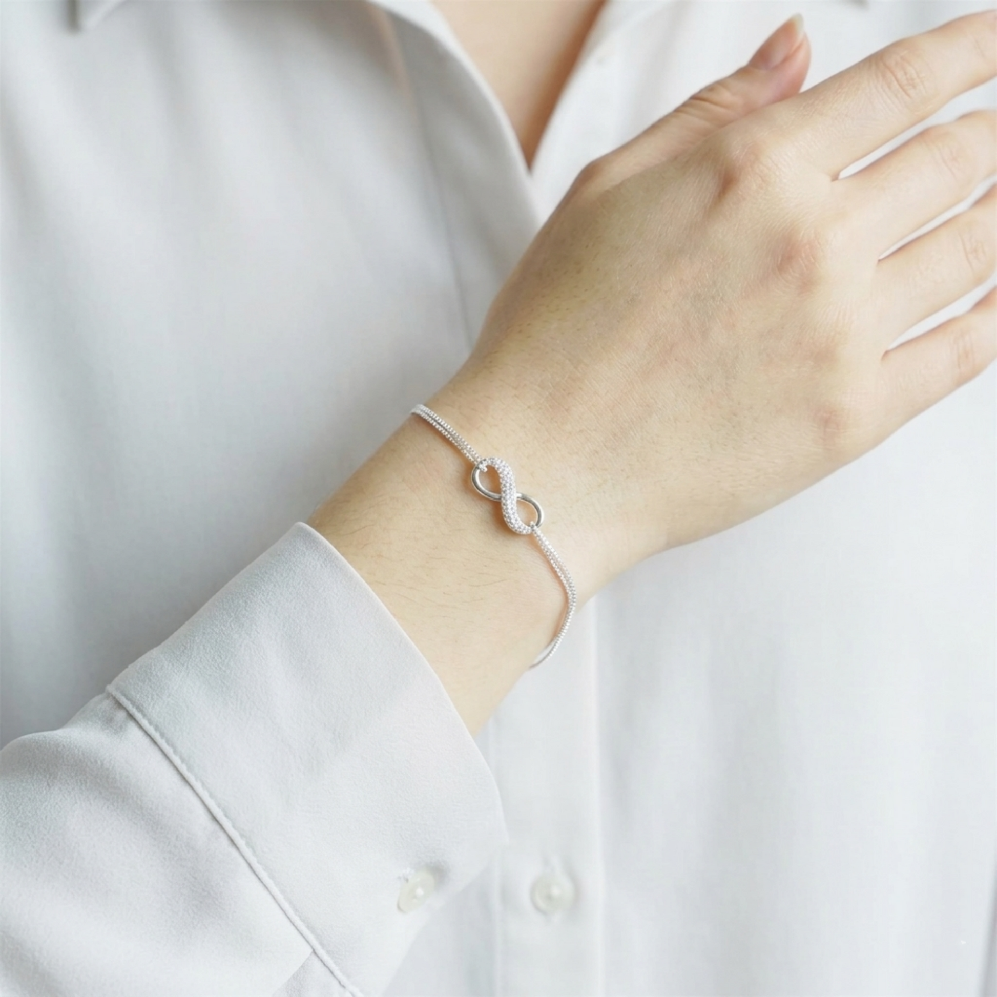 CZ Infinity bracelet on wrist: silver-toned infinity link bracelet