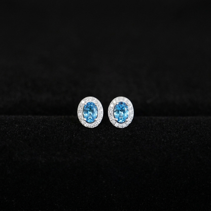Blue oval CZ halo stud earrings with clear pavé border, silver-tone