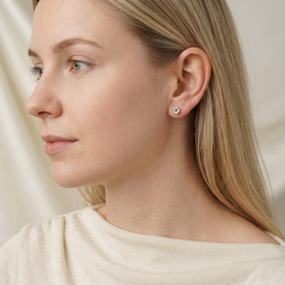 Silvertone Celtic Trinity knot stud earrings on ear, pin backs visible