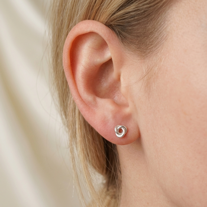 Celtic knot stud on earlobe, silvertone round trinity knot design