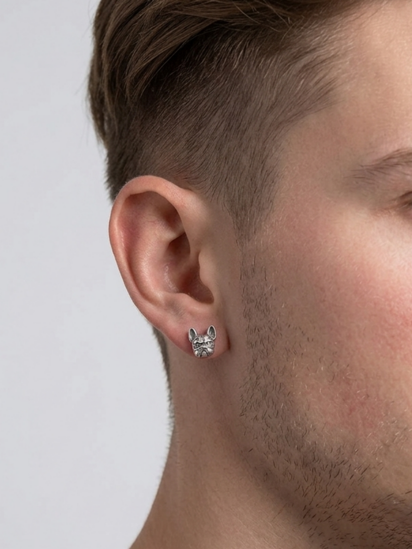 Oxidised Bulldog Studs worn on ear, small silver-toned bulldog face stud