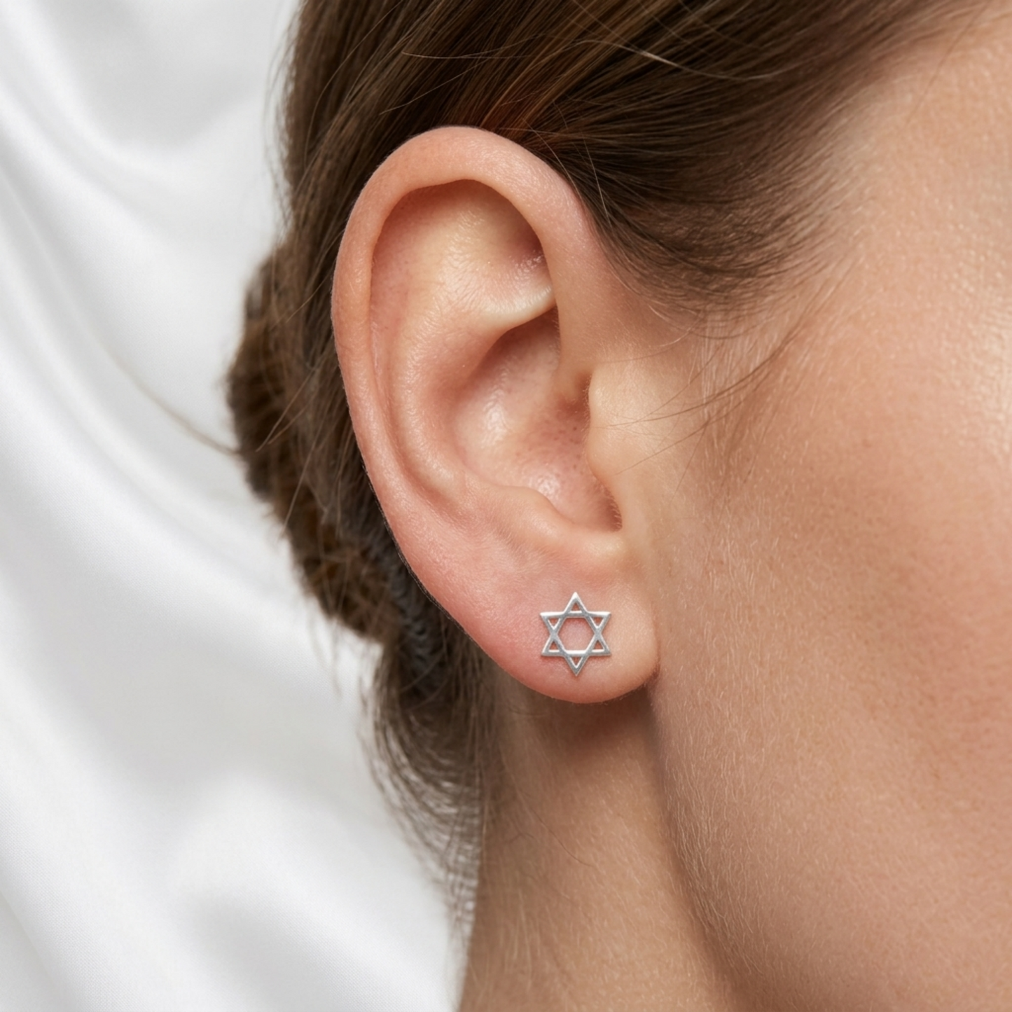 Hex Star of David stud earrings shown on ear, silver-tone hexagram