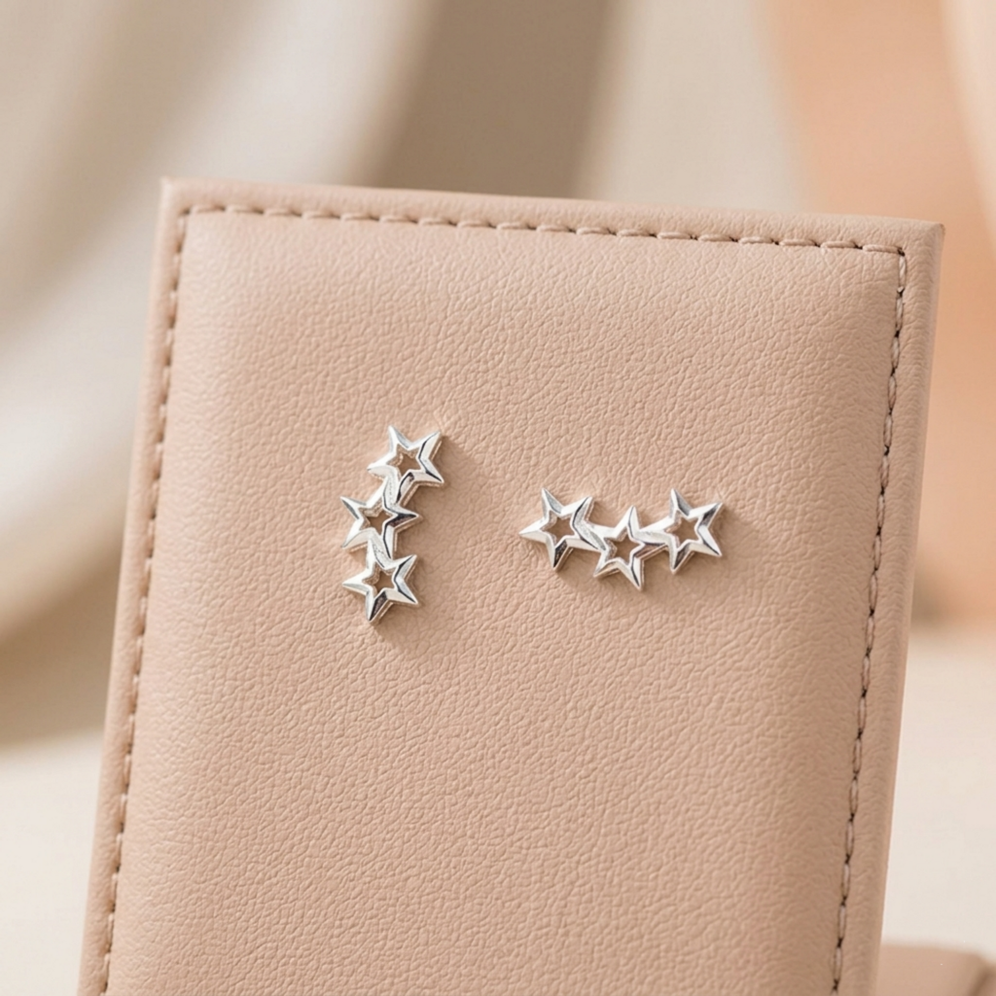 Star stud earrings, one vertical 3-star and one horizontal 5-star cluster, silver-tone