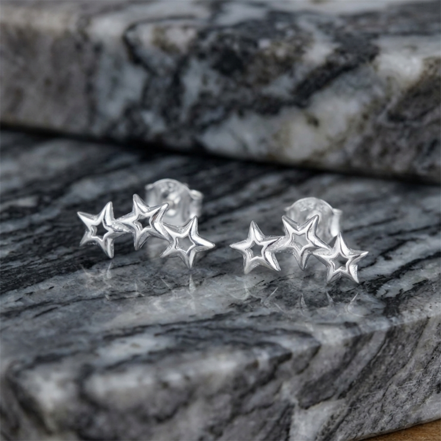 Star cluster stud earrings with hollow cutouts, silver-tone on gray stone