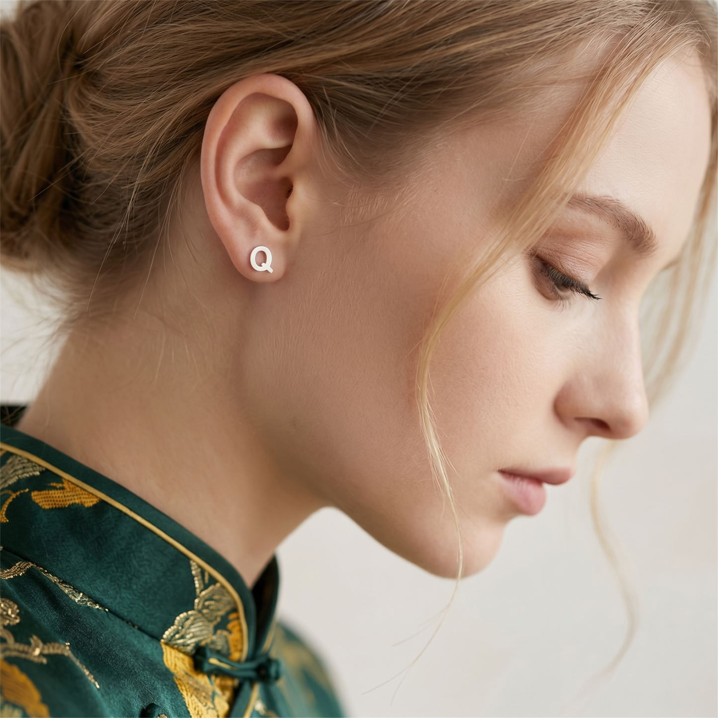 Q initial stud earrings, silver-tone studs on the ear