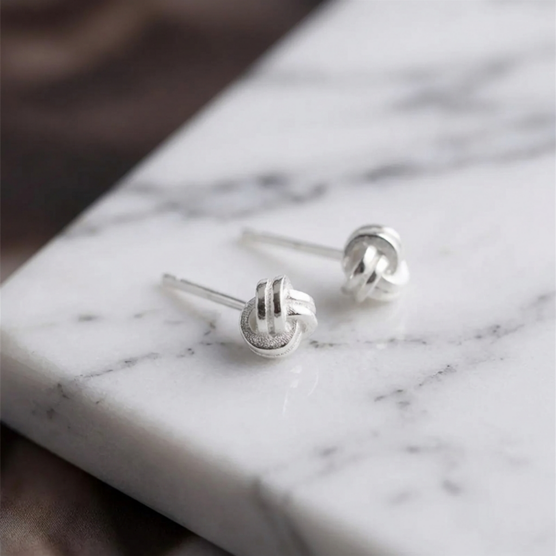 Mini Love Knot Ohrstecker, Detailansicht von vorne mit glänzender Metalloberfläche