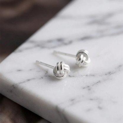 Mini Love Knot Ohrstecker, Detailansicht von vorne mit glänzender Metalloberfläche