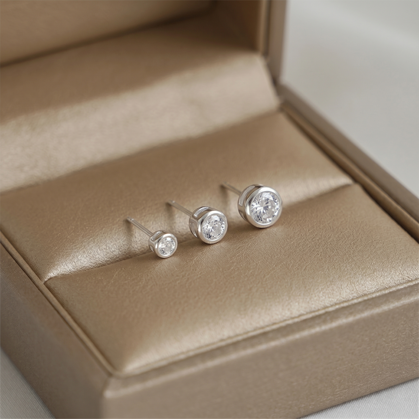 Bezel solitaire stud earrings, clear round stones with post backs and metal bezels