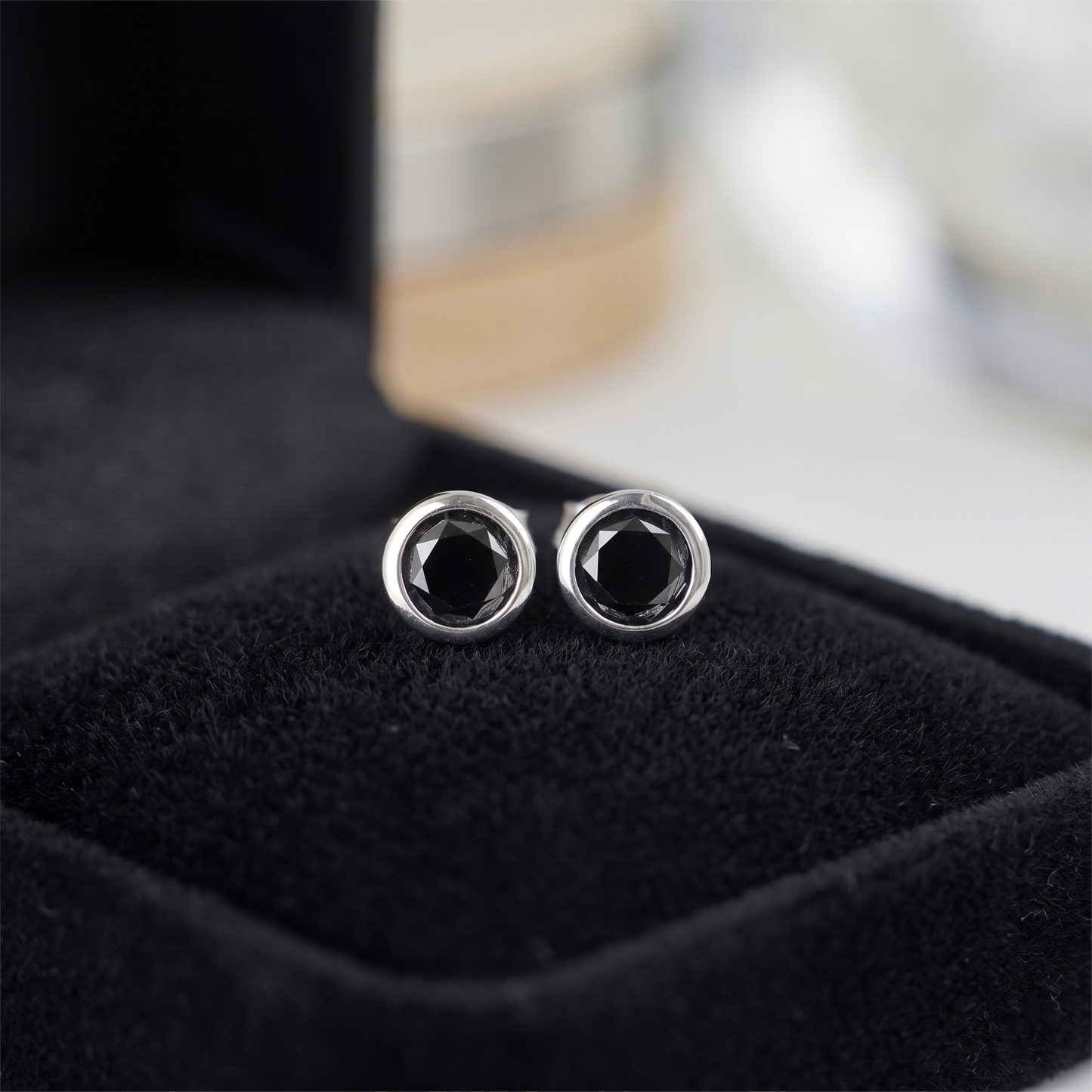 Black bezel solitaire stud earrings, round dark stone with silver-tone edge