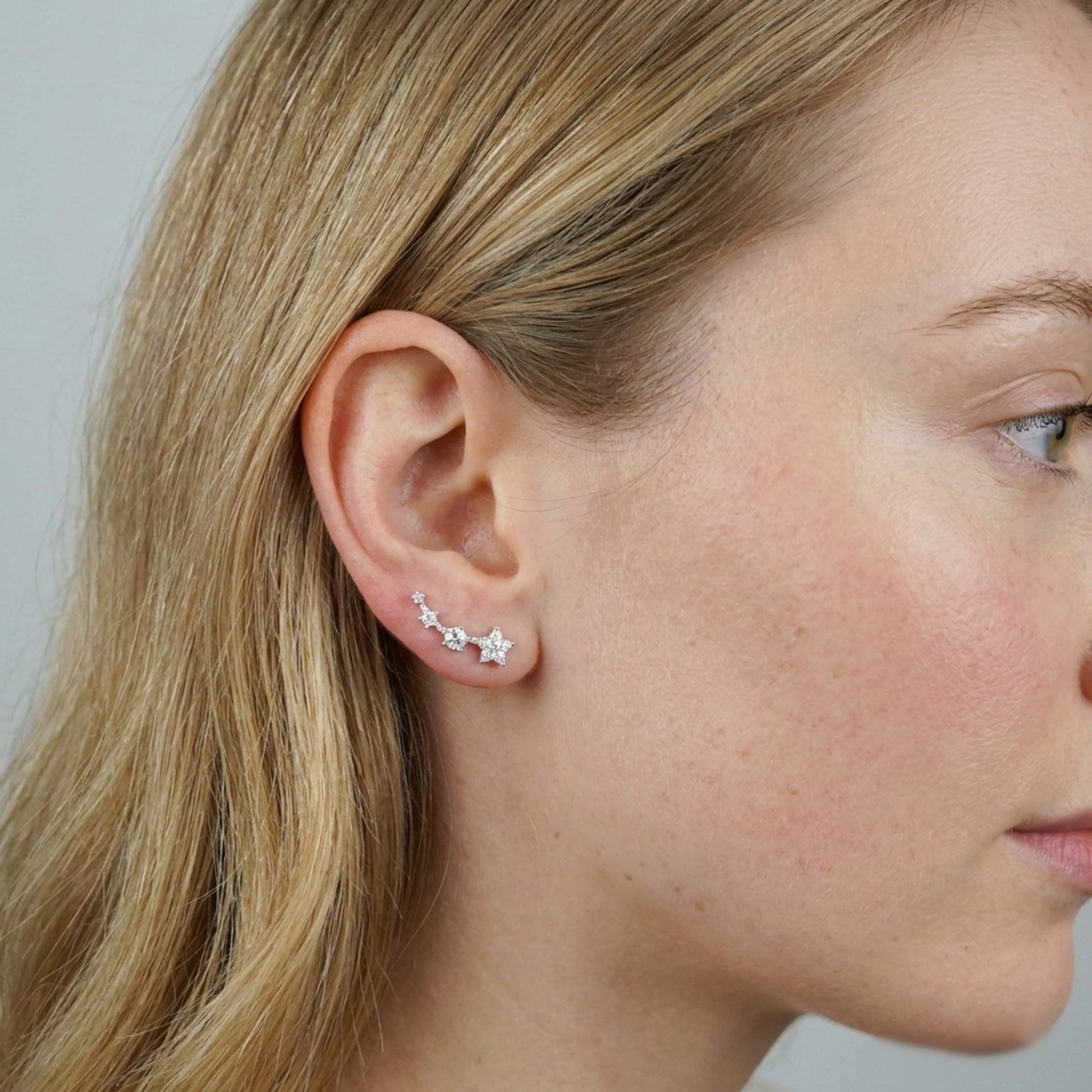 Star CZ ear climbers worn on ear: three linked sparkle stars across the lobe