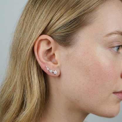 Star CZ ear climbers worn on ear: three linked sparkle stars across the lobe