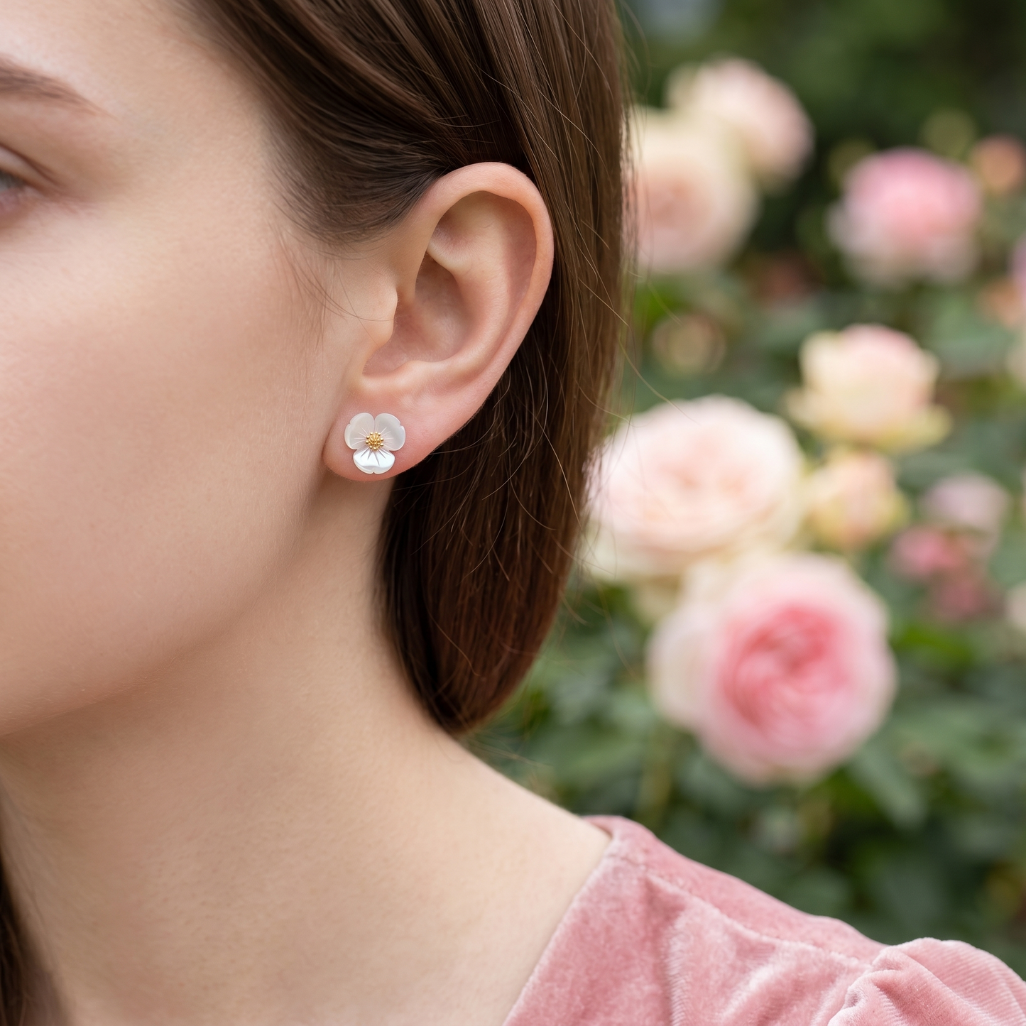Mother of Pearl shamrock stud earrings on ear, white petals with gold center