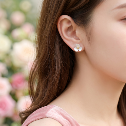 Shamrock stud earrings on ear, white mother-of-pearl petals and gold-tone center
