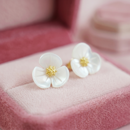 White mother-of-pearl shamrock stud earrings with gold centers, close-up front view