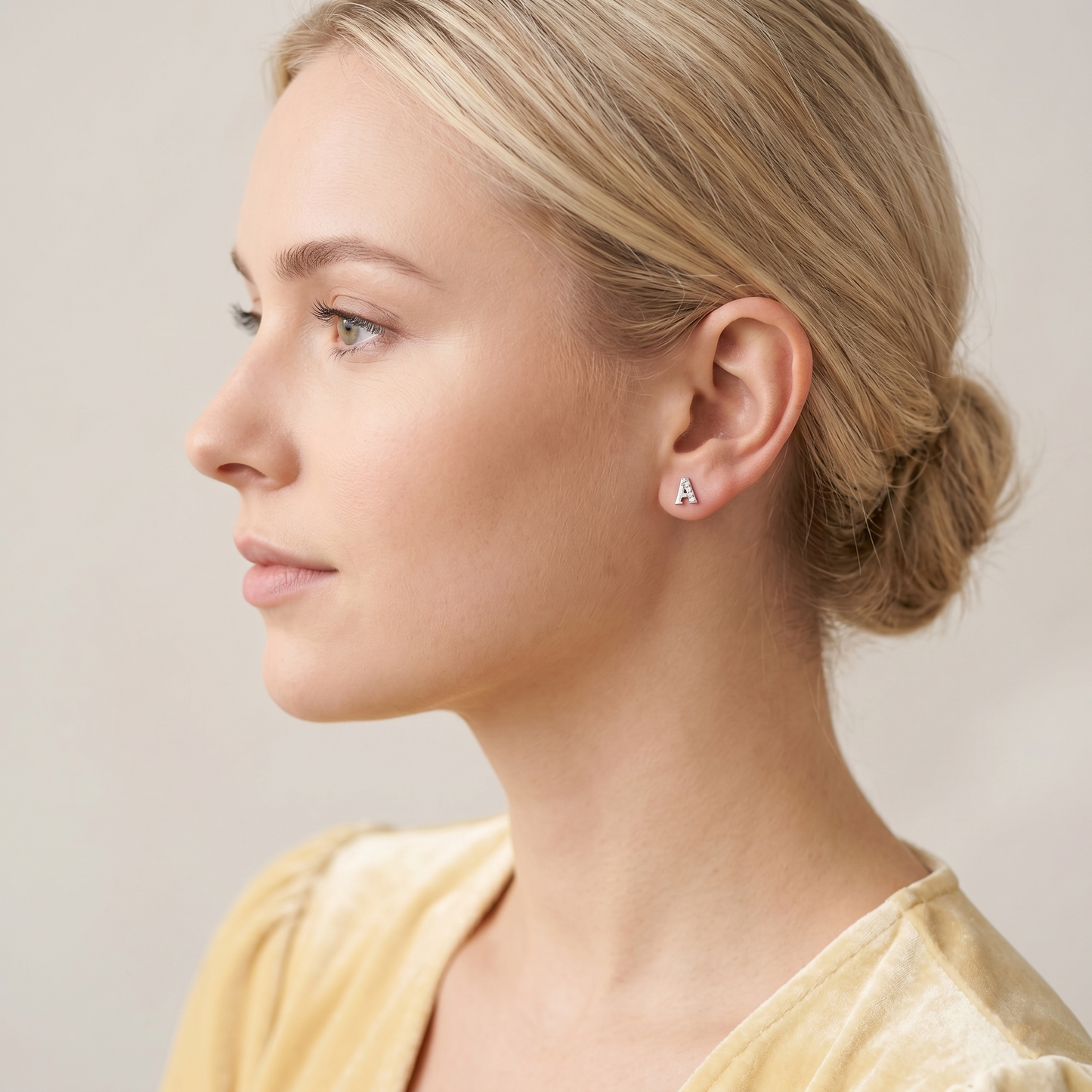 Mini CZ paved initial stud (A), silver-tone, worn on the ear