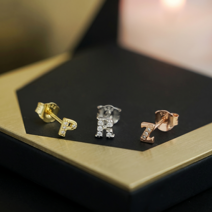 Mini CZ paved initial studs in gold, silver-tone, and rose gold—P, R, Z shown