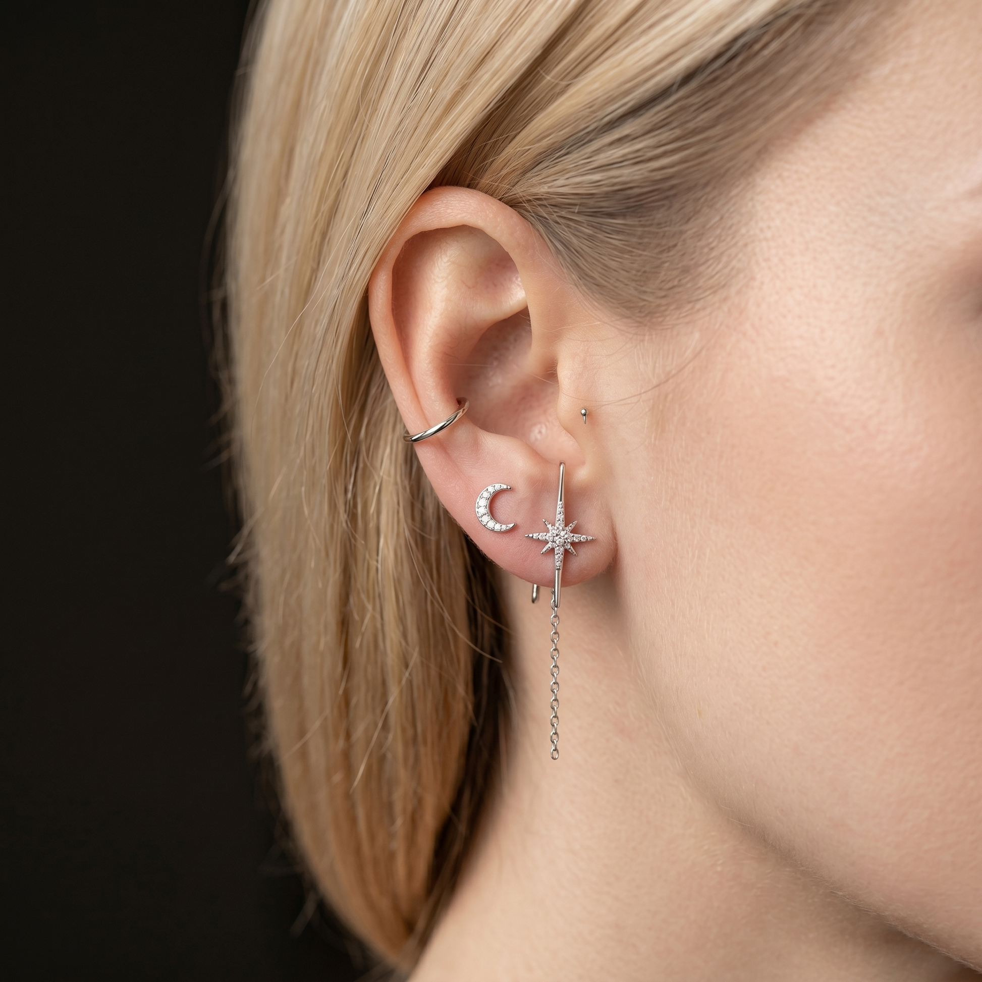 North Star suspender studs in rhodium-tone on ear, star stud with small chain drop