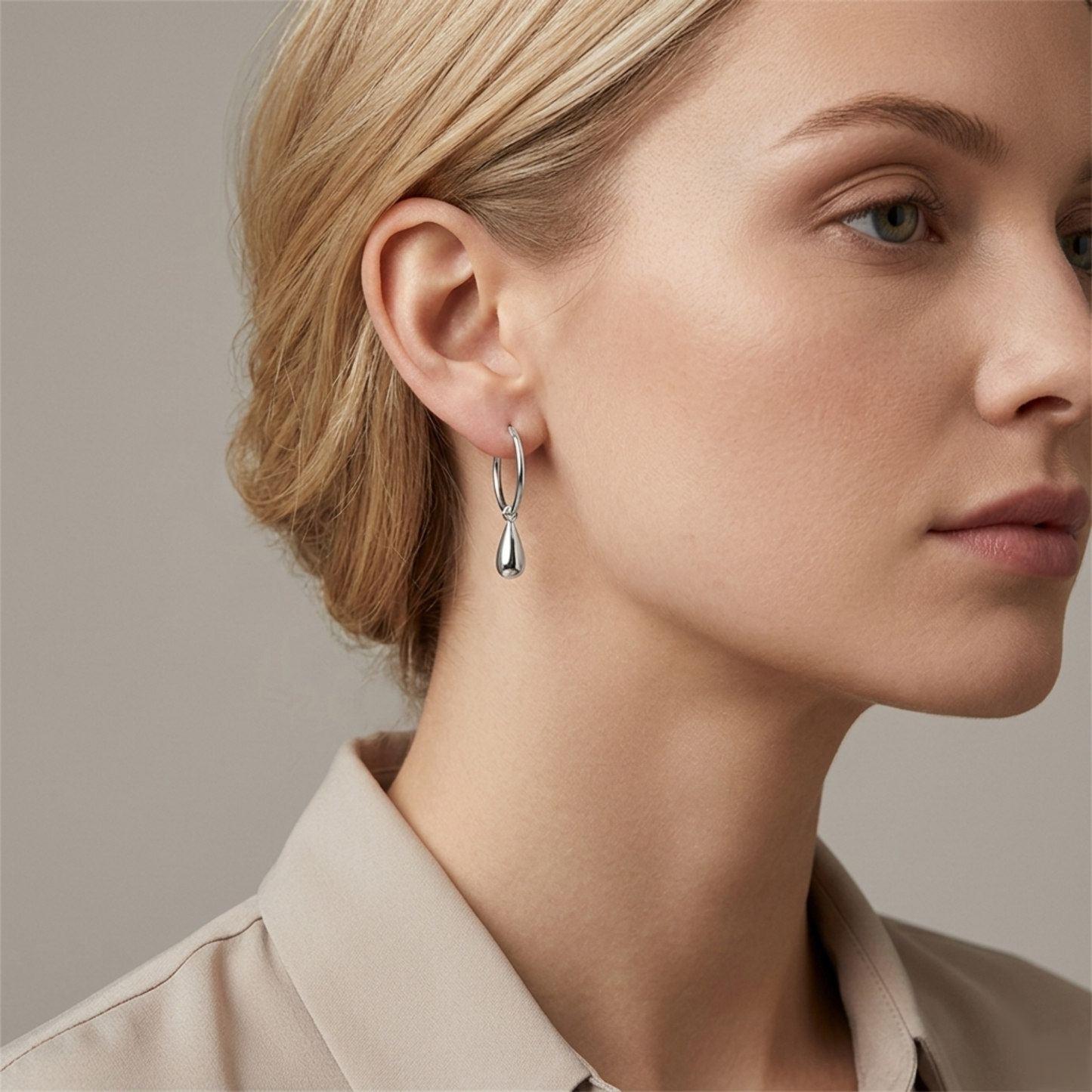 Silver teardrop hoop earrings worn on ear, hoop with teardrop charm