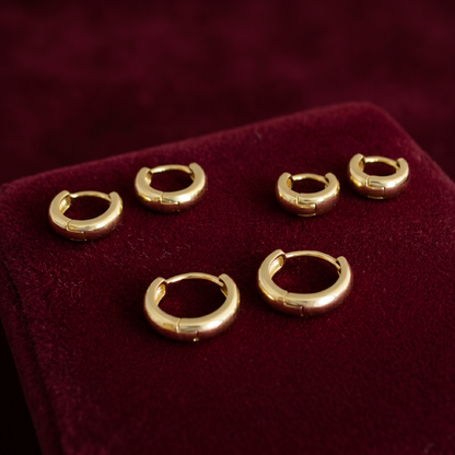 Gold and silver-toned 3mm sleeper huggie hoops on display