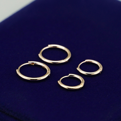 Rhodium 2mm sleeper huggies, multiple small hinge hoops on display