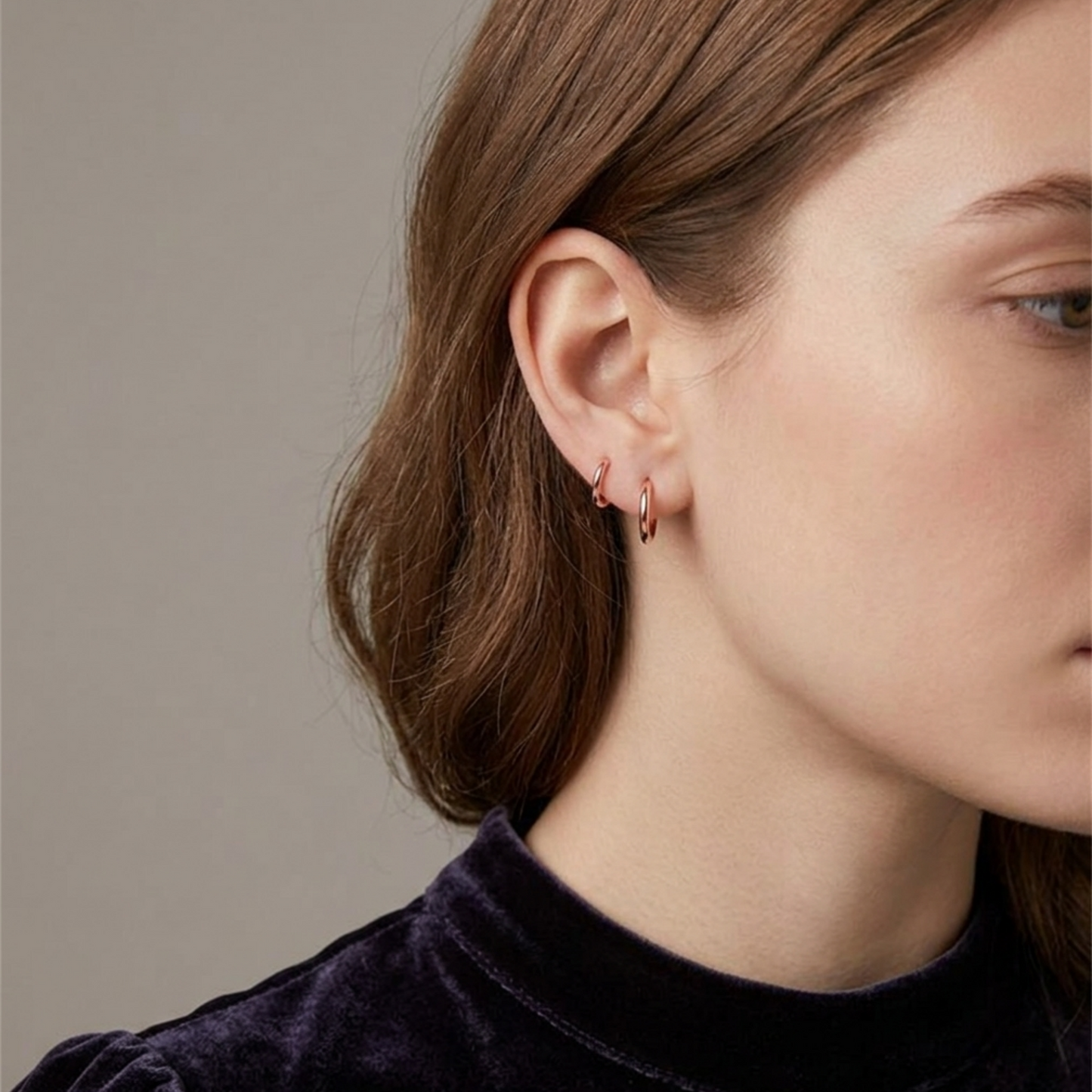 Rose Gold 2mm sleeper huggies worn on ear, small round hoop earrings