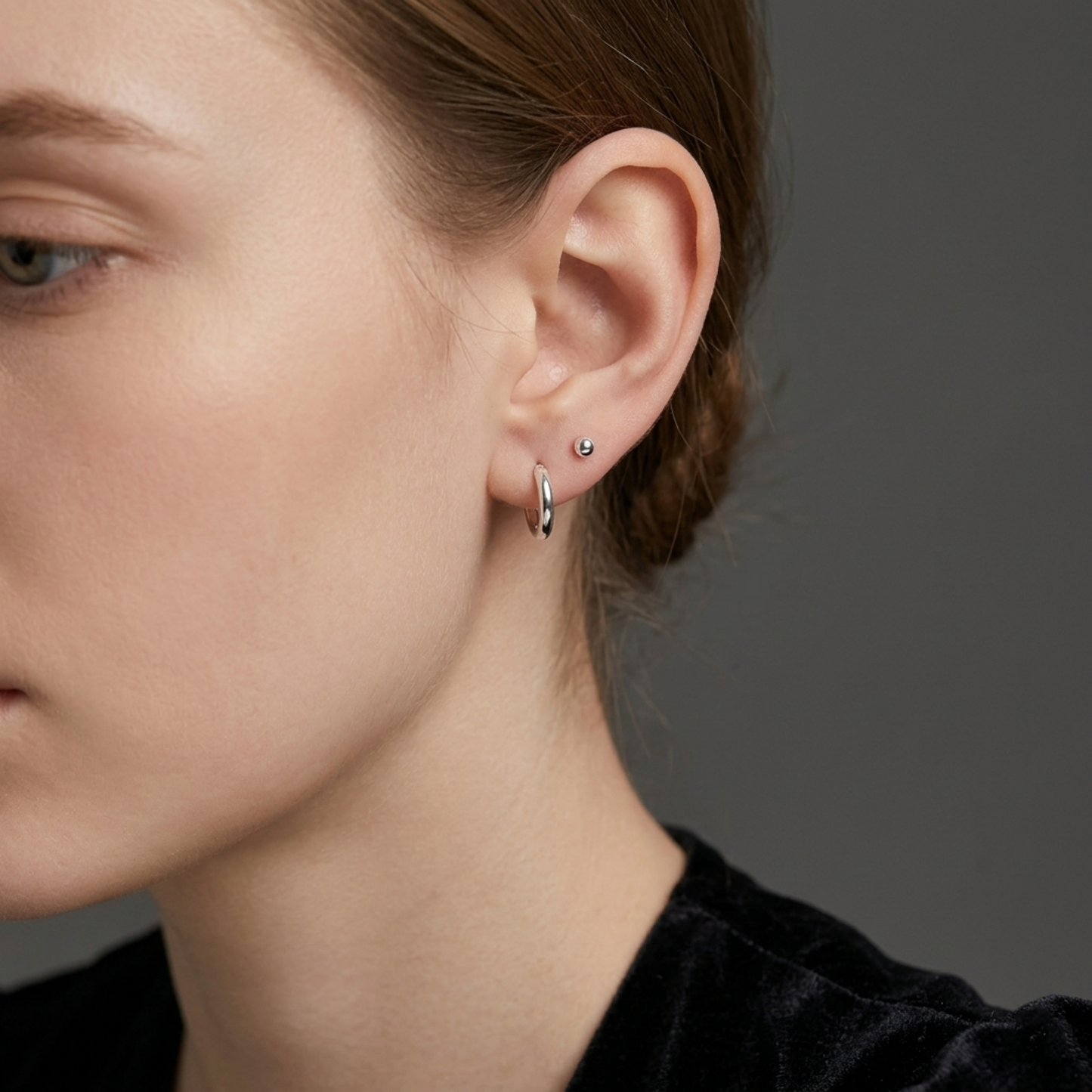 Rhodium 2mm sleeper huggies worn on ear, small round hoop earring